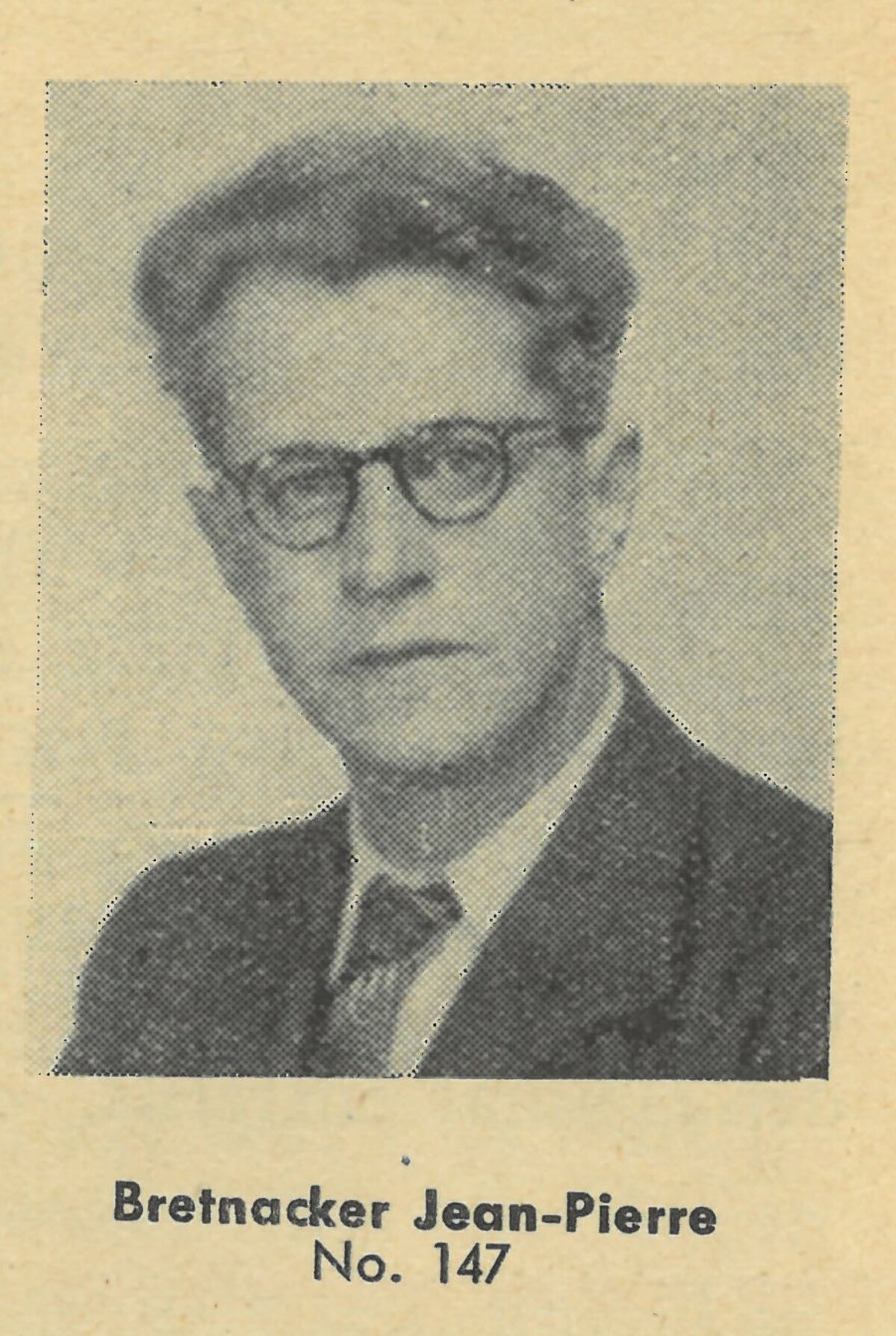 Porträtfoto von Jean-Pierre Bretnacker zeigt seine Gesicht und Schulter, er trägt eine Brille und einen Anzug mit Krawatte. Das Foto ist schwarz-weiss und stammt aus der Publikation François Goldschmitt, Elsässer und Lothringer in Dachau, Nr. 2. Im Zugangsblock, Metz 1946. Darin hat das Foto die Nummer 147.